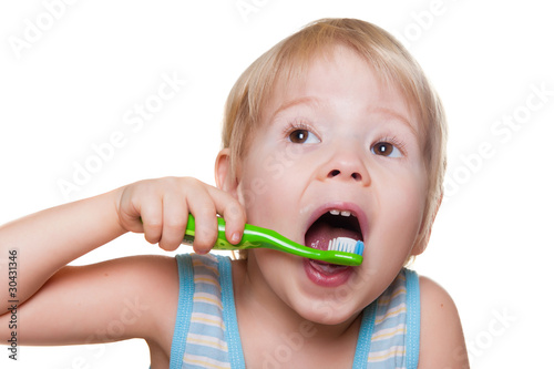 child brushes his teeth