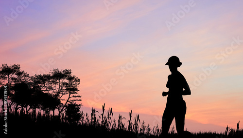 Female jogger silhouette against stunning colorful sunset sky