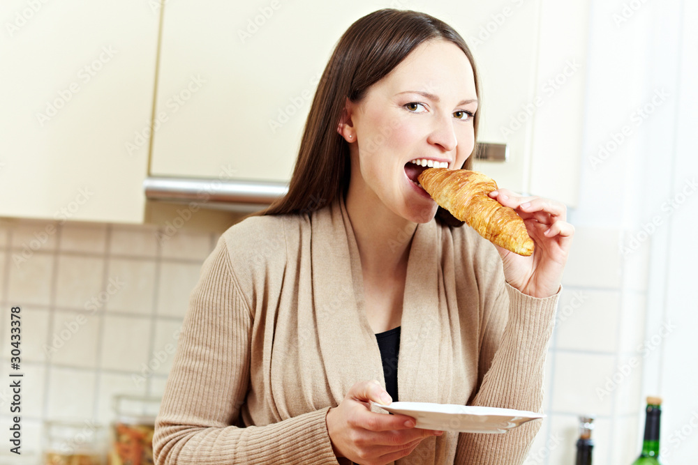 Frau beißt in Croissant Stock Photo | Adobe Stock