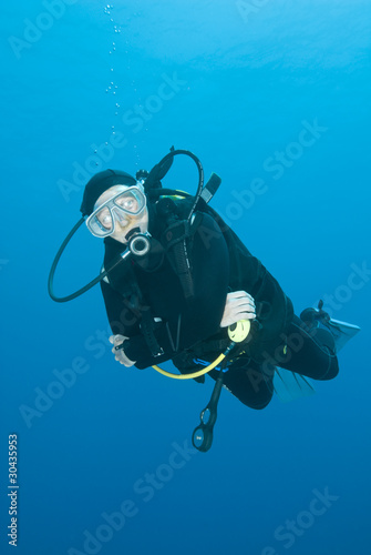 Adult female scuba diver in the blue.