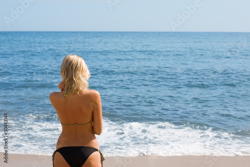 Girl on the sandy beach by the sea. © Stanislav Komogorov