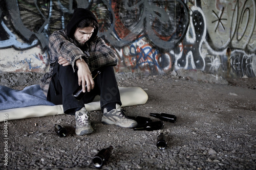 Homeless alcoholic drinking beer photo