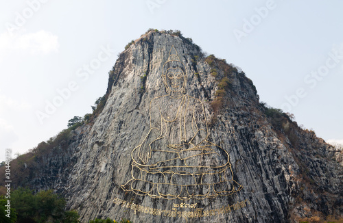 gold painting of buddha statue on cliff
