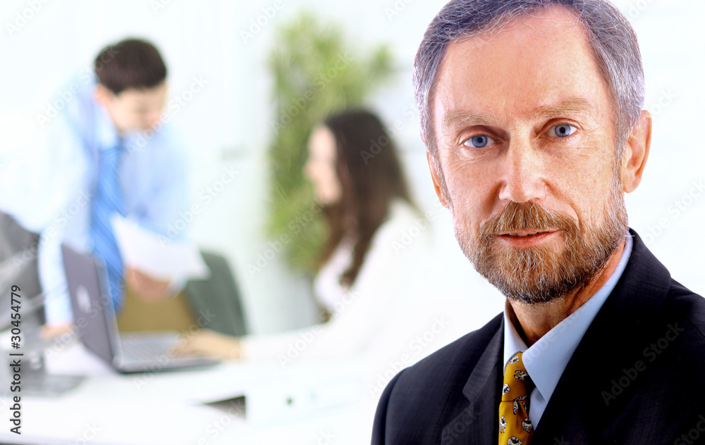 Closeup portrait of mature business man with colleagues Closeup portrait of mature business man with colleagues