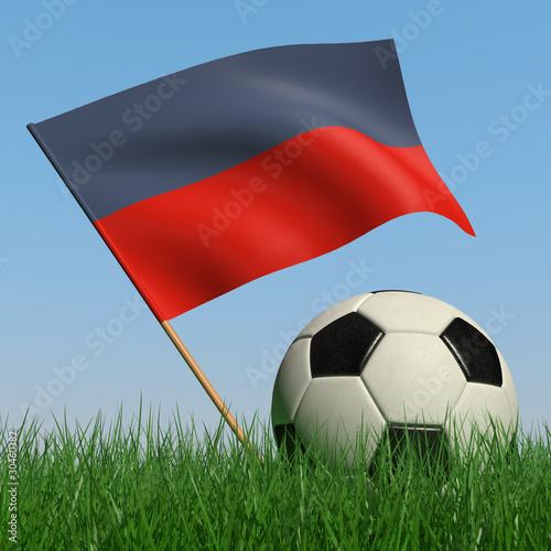 Soccer ball in the grass and the flag of Haiti