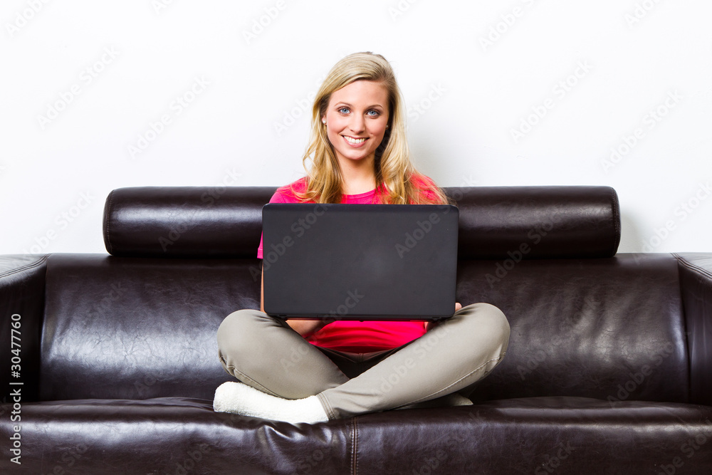 blonde frau mit laptop auf dem sofa blonde frau mit laptop auf dem sofa