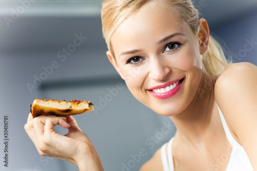 Young happy woman with pizza  indoors