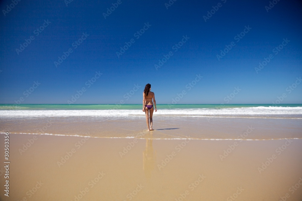 woman walking at seashore in Conil beach