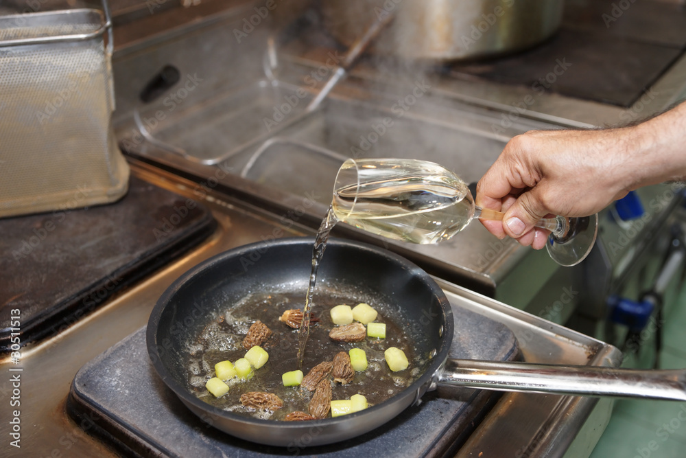 Chef is adding white wine in pan Chef is adding white wine in pan