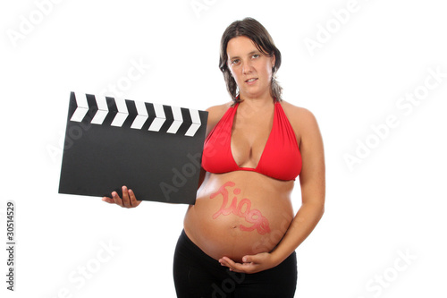 pregnant woman with beautiful belly holding movie clacket photo