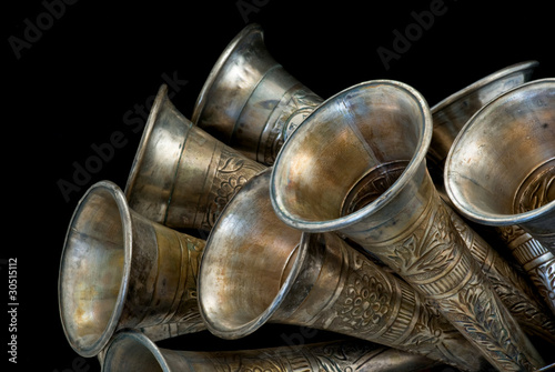 Closeup of metal horns tilted upwards on black background.