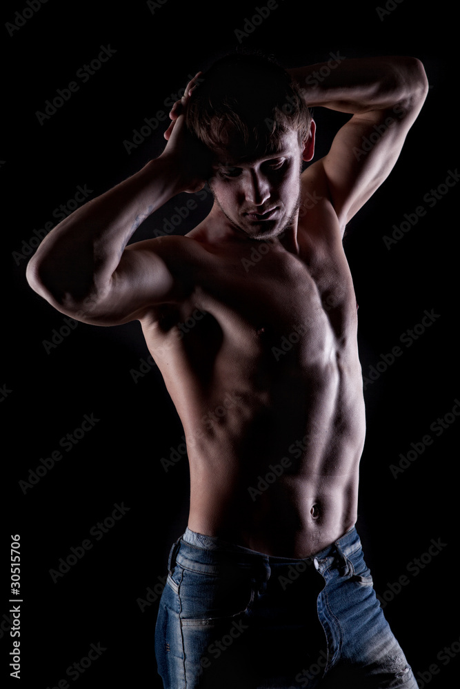 Posing muscular naked man on black