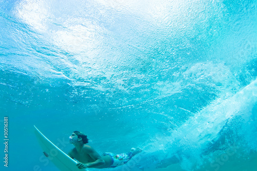 surfer water shot diving under wave white surfboard text