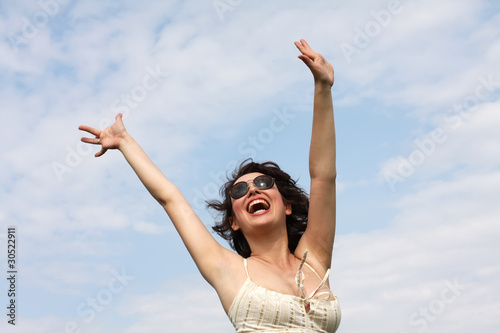 Happy woman with open hands under sky