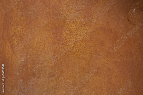 Stained orange plaster wall with rust