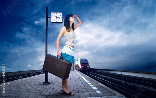Girl waiting train on the platform of railway station