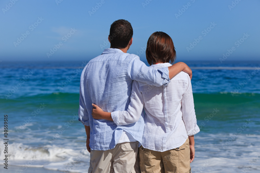 Enamored couple looking at the sea Enamored couple looking at the sea
