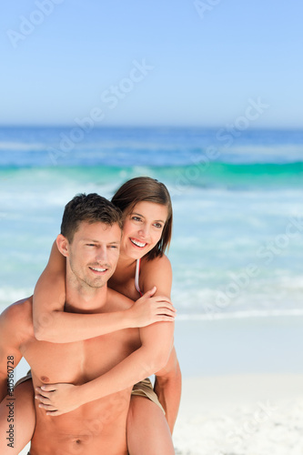 Man having wife a piggyback on the beach