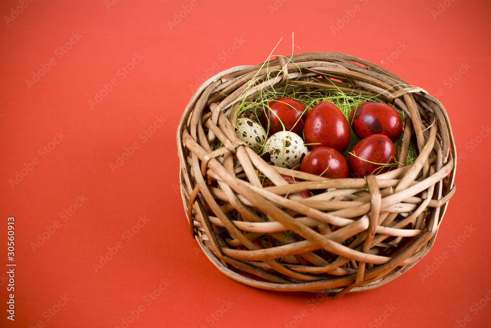 Easter eggs in wicker basket on red background Easter eggs in wicker basket on red background