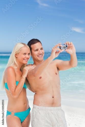 Couple taking a photo of themselves on the beach