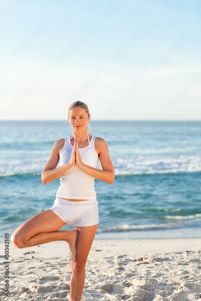 Woman practicing yoga on the beach Woman practicing yoga on the beach