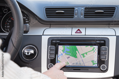 GPS navagation in modern car. Finger pointing destination.