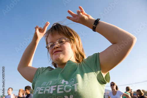 Foto A girl with Dow Syndrome dancing at an outdoor concert.