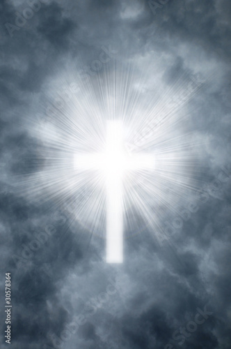 Religious cross shining through clouds