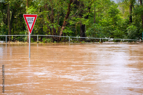 Very flooded road and give way sign, Queensland, Australia