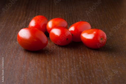 Several cherry tomatoes on a wood table