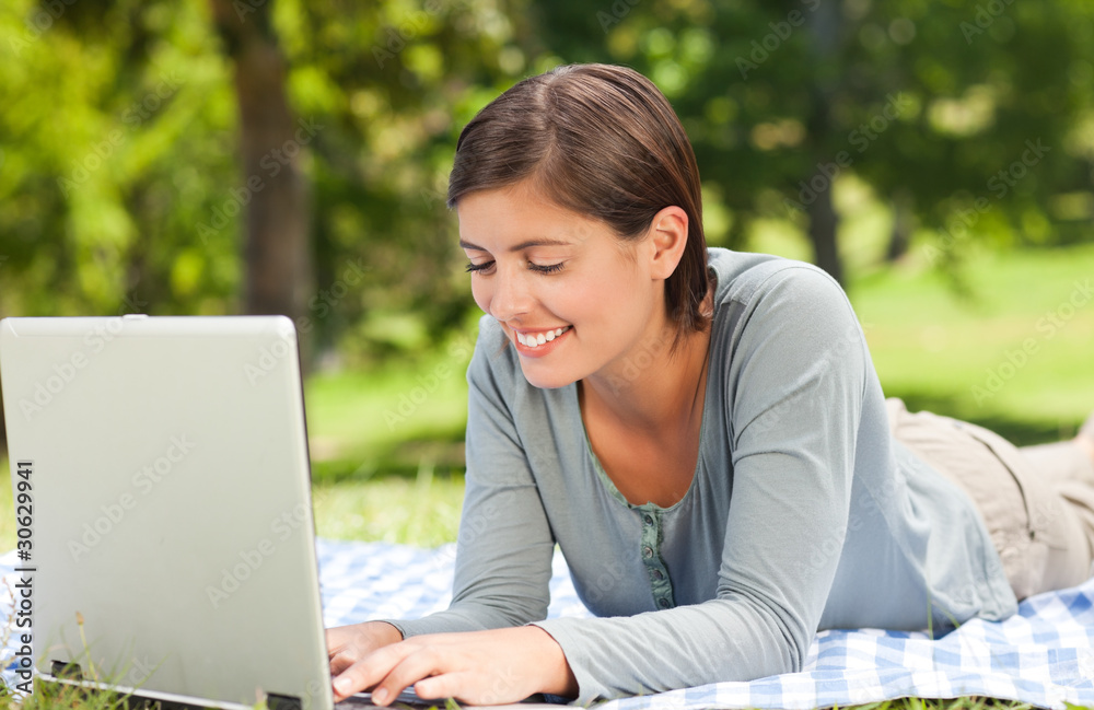 Woman working on her laptop in the park Woman working on her laptop in the park