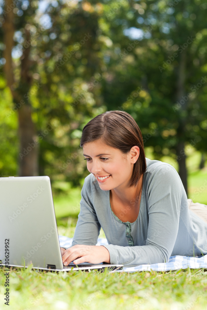 Woman working on her laptop in the park Woman working on her laptop in the park