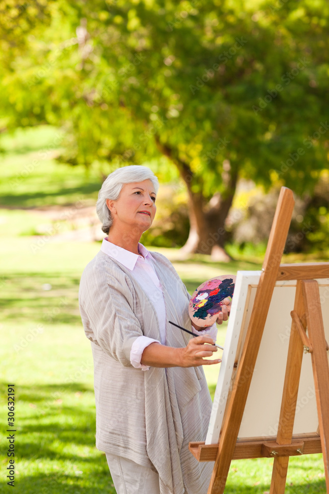 Fototapeta premium Senior woman painting in the park
