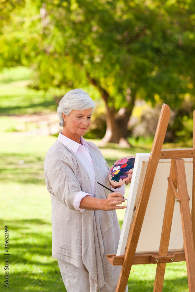 Fototapeta premium Senior woman painting in the park