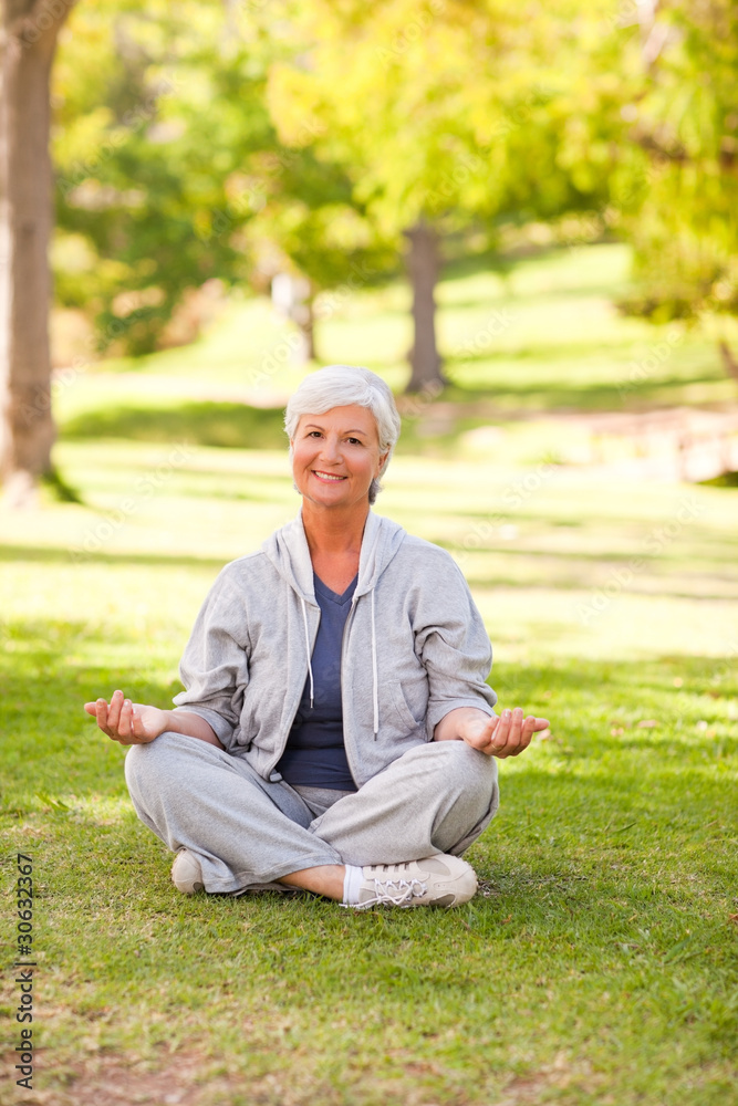 Mature woman practicing yoga in the park Mature woman practicing yoga in the park