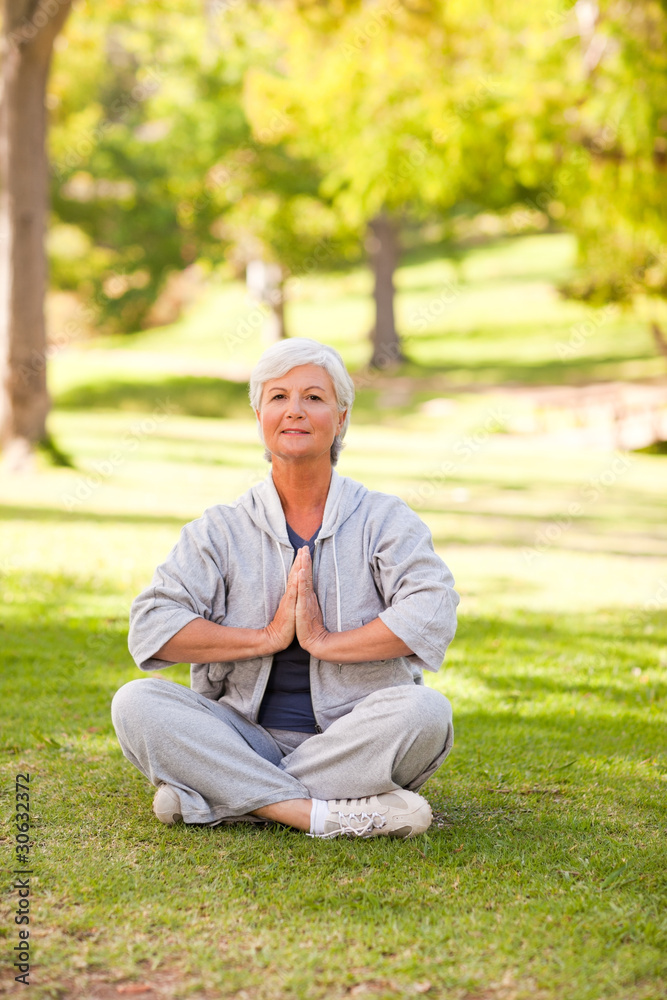 Mature woman practicing yoga in the park Mature woman practicing yoga in the park