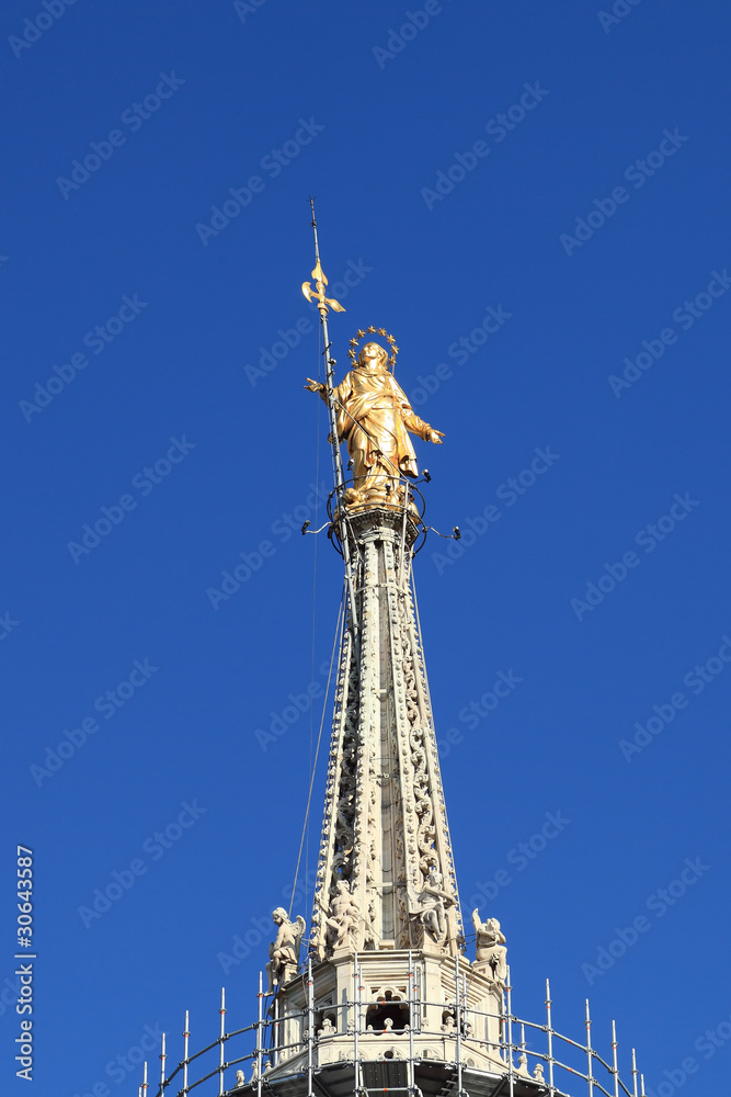 the golden madonnina of Duomo, symbol of Milan, Italy the golden madonnina of Duomo, symbol of Milan, Italy