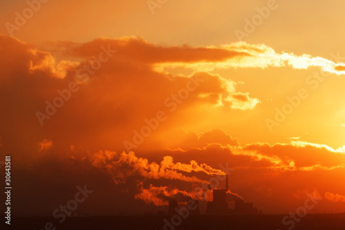 Power plant with smoke at sunset