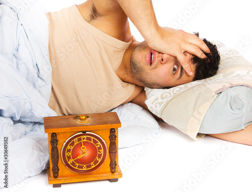 Young man wakes to a loud alarm clock photo