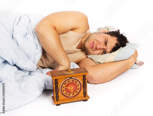 Young man wakes to a loud alarm clock photo