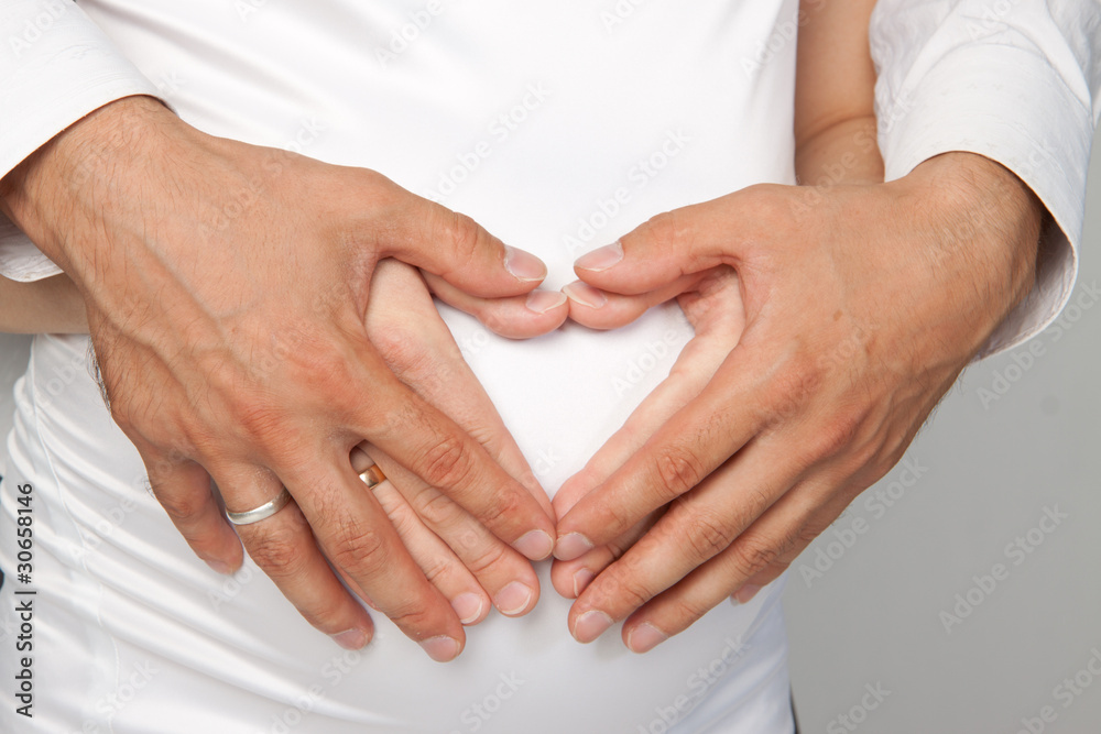 Heart shaped hands of pregnant woman and her husband Heart shaped hands of pregnant woman and her husband