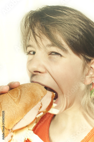 Teen girl eats a huge hamburger