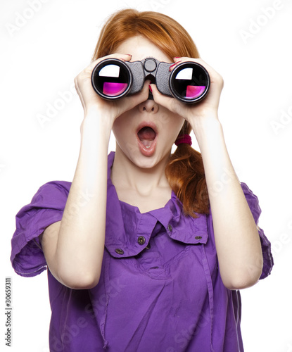 Teen red-haired girl with binoculars isolated on white backgroun