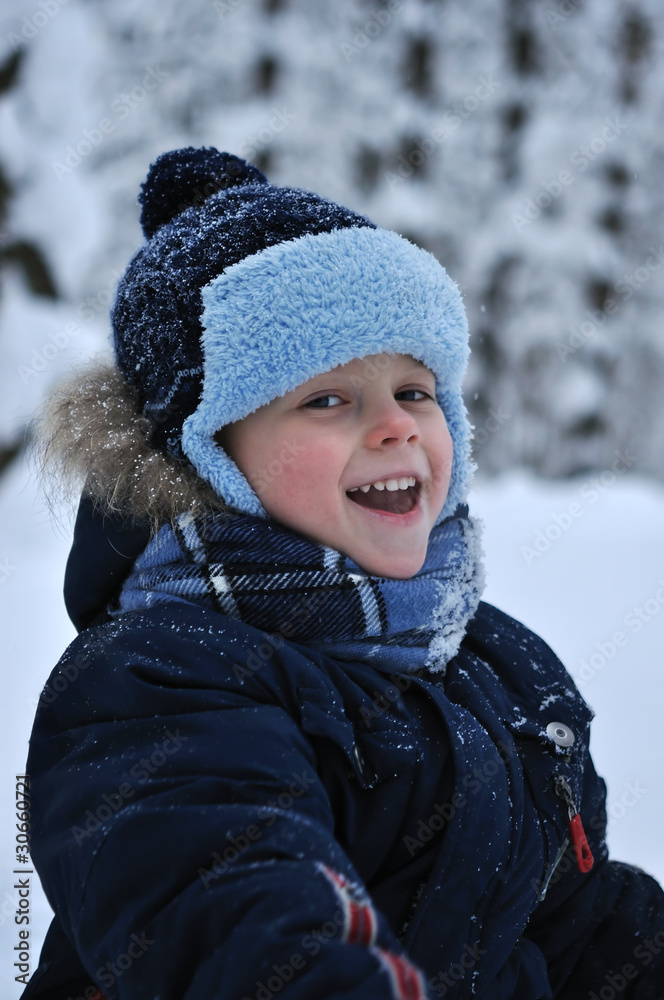 Portrait of a little boy in the winter forest