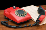 Red phone on a wooden table