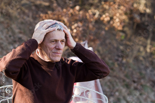 Portrait of worried senior man in nature. White-haired bored man