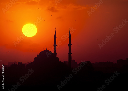 The sun sets behind a silhouetted mosque in Istanbul, Turkey