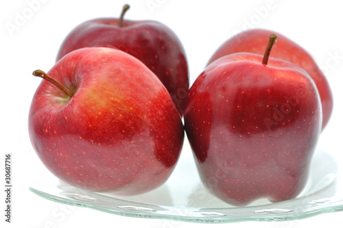 czerowne soczyste jabłka na szklanym talerzu