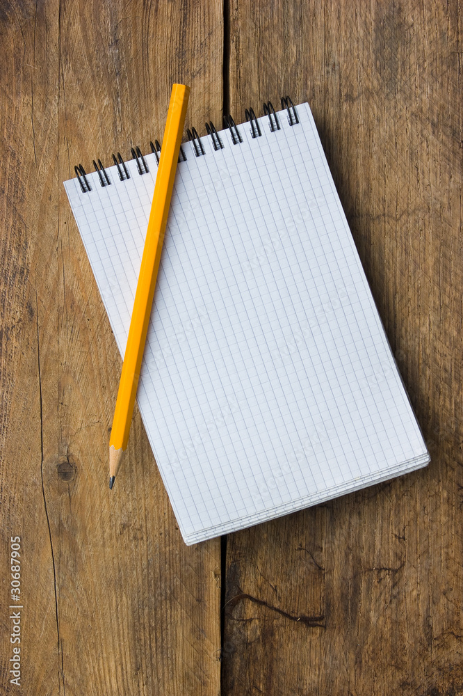 Notepad and pencil on the background of the wooden planks Notepad and pencil on the background of the wooden planks