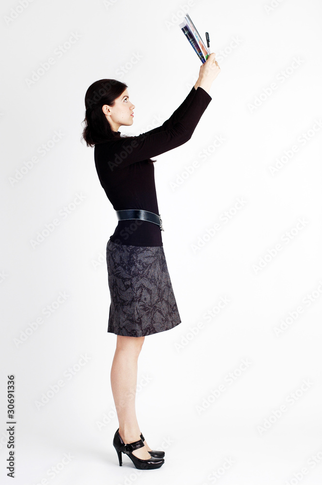 Young beautiful woman with magazine and pen standing tall Young beautiful woman with magazine and pen standing tall